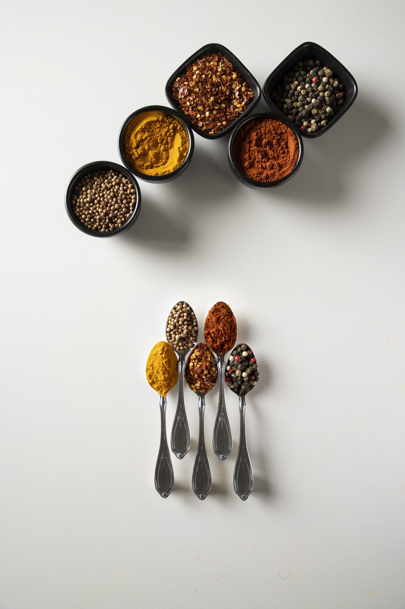 Five Spoons with spices and small bowls with spices